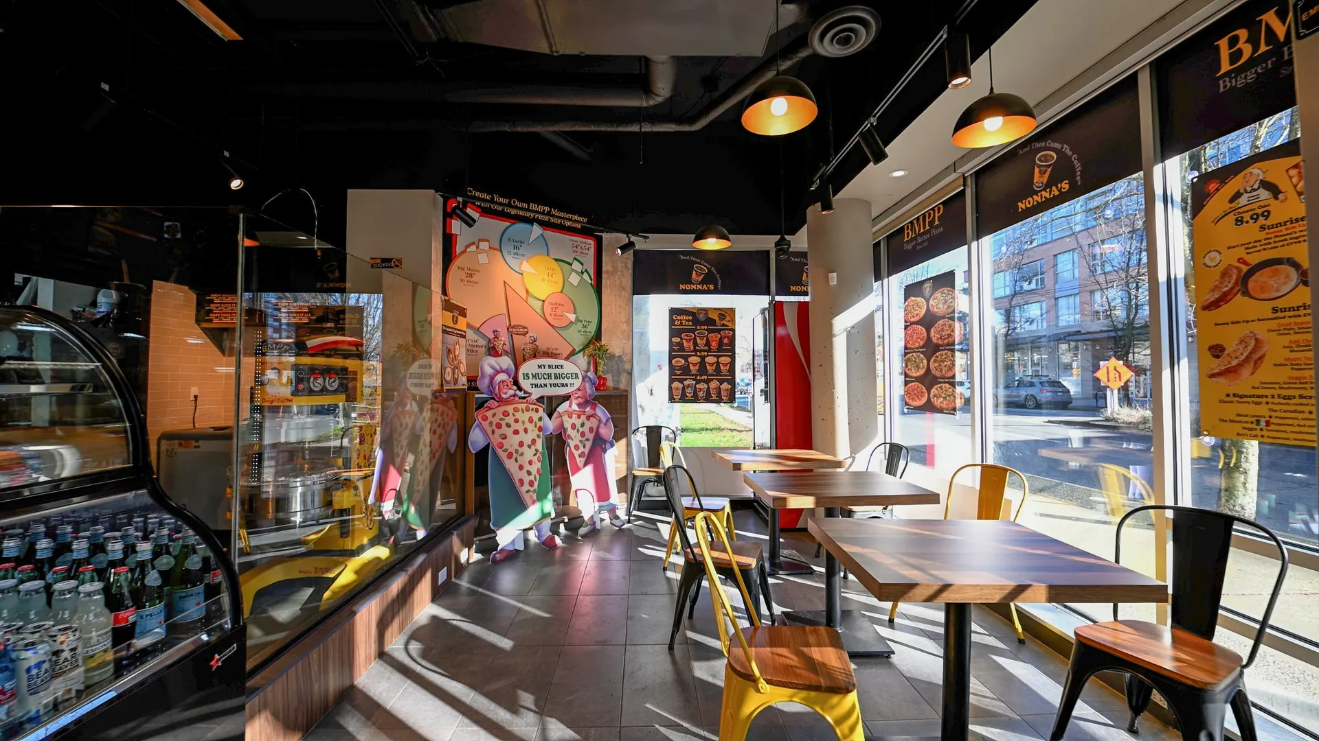 Customer dining tables with glass observation window overlooking pizza preparation area — BIG MAMA'S & PAPA'S PIZZERIA — SURREY, BC