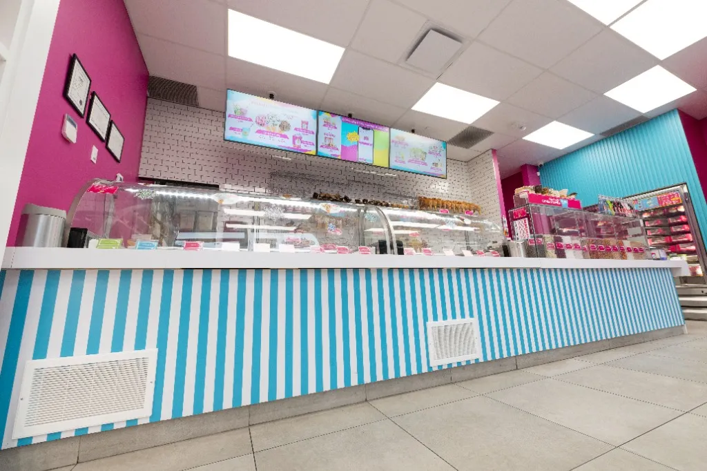 Blue-and-white striped service counter beneath digital menu screens — MARBLE SLAB CREAMERY — SURREY, BC