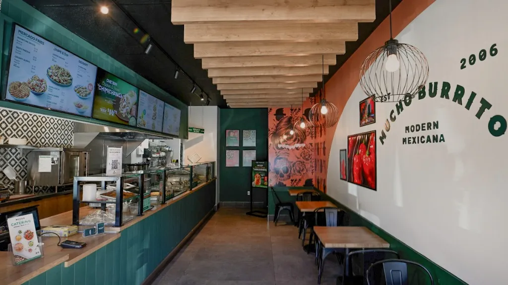 Food service counter with glass display, overhead menus and timber ceiling slats — MUCHO BURRITO — SURREY, BC